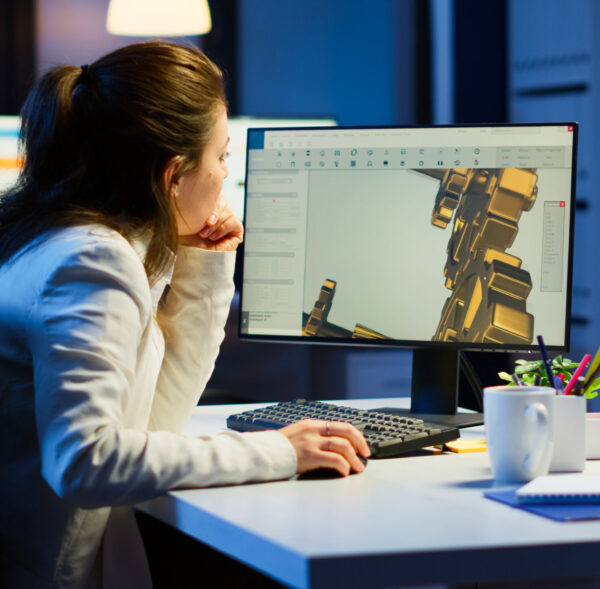 Tired woman architect working on modern cad program overtime sitting at desk in start-up office. Industrial female engineer studying prototype idea on pc showing cad software on device display